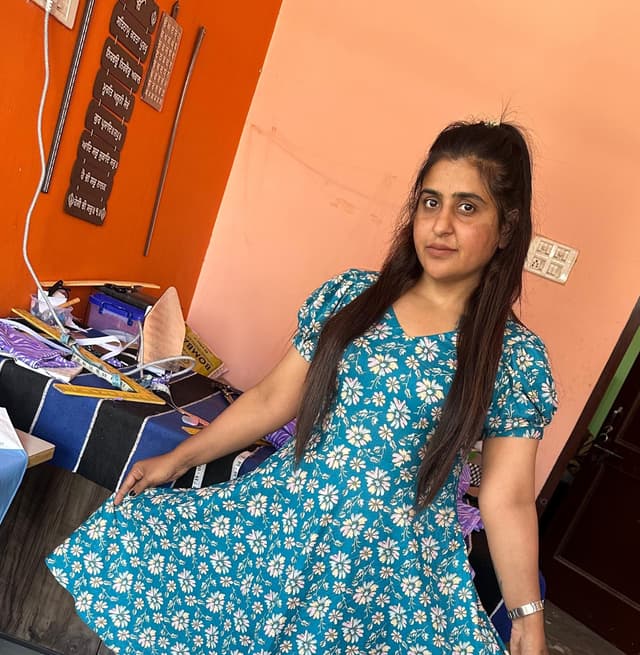 A student proudly showing their finished tailoring project